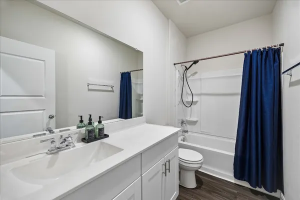a bathroom with a granite countertop sink toilet a shower and a mirror