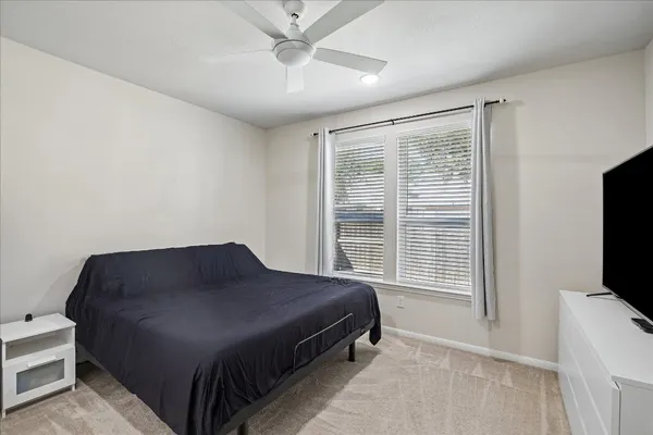 a bedroom with a bed tv and a window