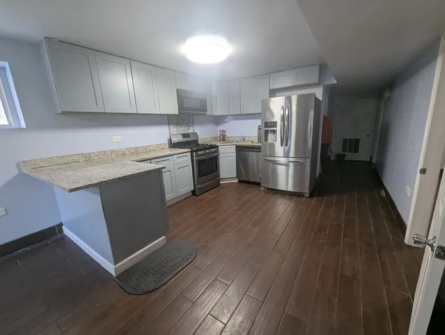 a kitchen with granite countertop a sink cabinets and stainless steel appliances