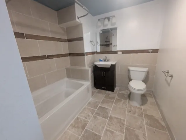 a bath room with a toilet and a bath tub