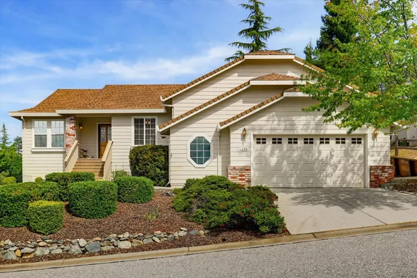 a front view of a house with a yard and potted plants