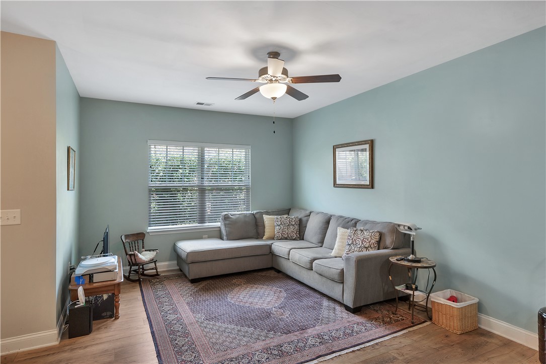 121 Ventura Street Anderson, SC 29621 - Photo 21 of 32 A comfortable living space featuring a broad window, warm wood flooring, and a ceiling fan for optimal air circulation.