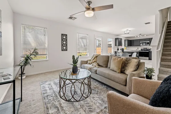 a living room with furniture kitchen view and a window