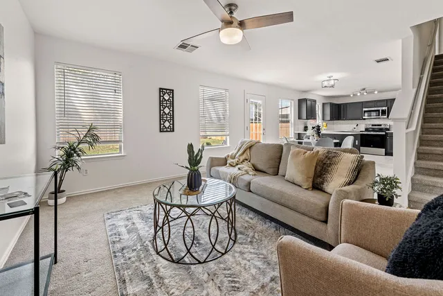a living room with furniture kitchen view and a window