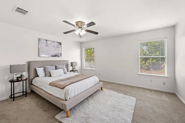 a spacious bedroom with a large bed and a chandelier