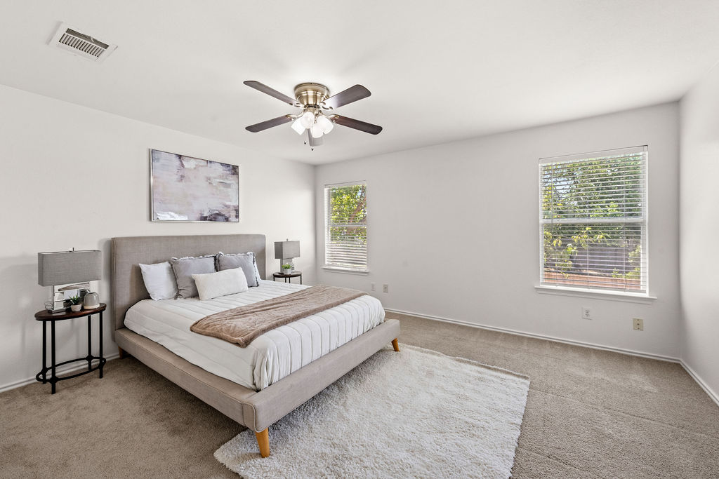 525 Meadow Park Drive Georgetown, TX 78626 - Photo 19 of 39 a spacious bedroom with a large bed and a chandelier