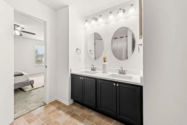 a en suite bathroom with a double vanity sink and a mirror