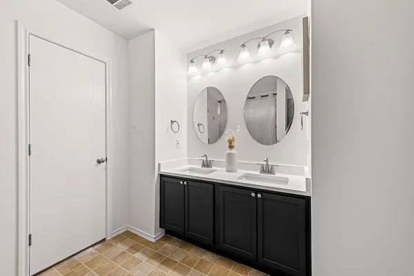 a bathroom with a double vanity sink and a mirror