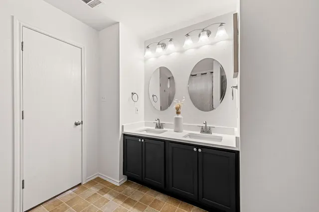 a bathroom with a double vanity sink and a mirror