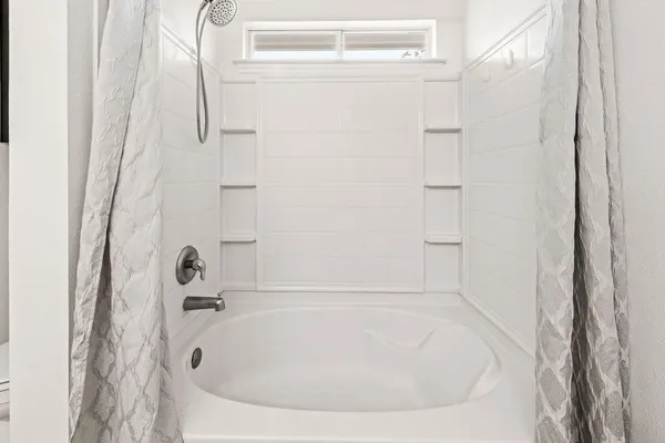 a white bath tub sitting next to a white sink