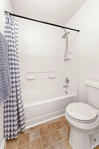 a bathroom with a toilet and a shower
