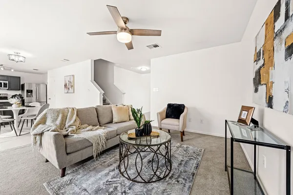 a living room with furniture a rug and white walls