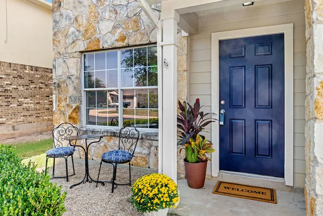 a front view of a house with outdoor seating and potted plants