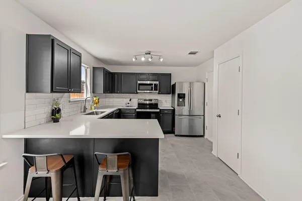 a kitchen with kitchen island a refrigerator stove and microwave