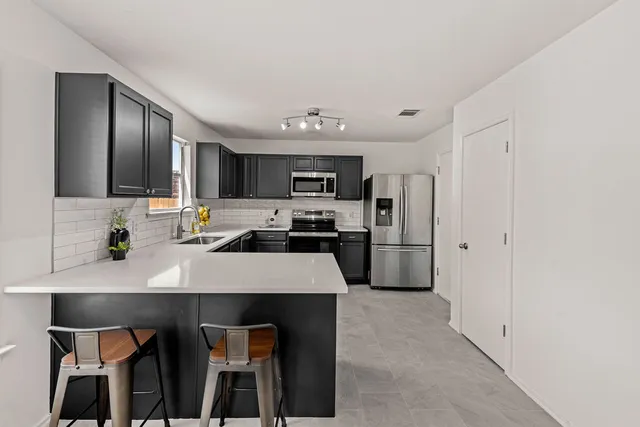 a kitchen with kitchen island a refrigerator stove and microwave