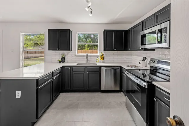 a kitchen with a sink stove top oven and refrigerator