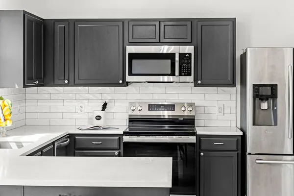 a kitchen with stainless steel appliances a stove microwave and refrigerator