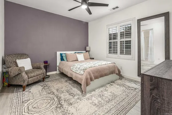 a bedroom with a bed a couch and a window
