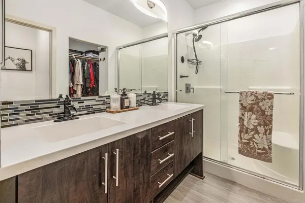 a bathroom with a double vanity sink a mirror and a shower