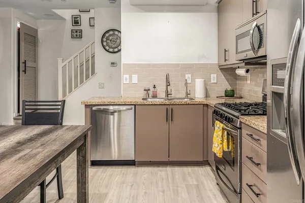 a kitchen with stainless steel appliances granite countertop a stove a sink and a refrigerator