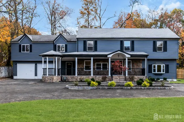 a front view of a house with swimming pool and chairs