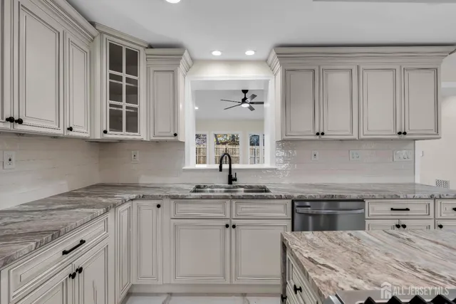 an empty room with wooden floor ceiling fan and windows