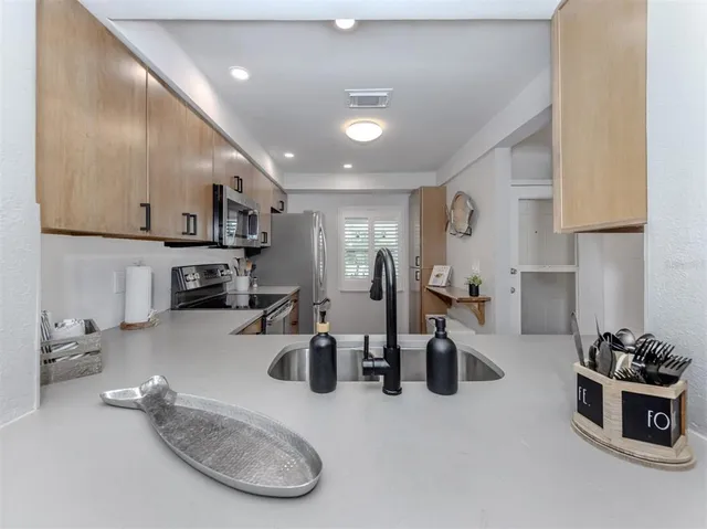 a kitchen with sink refrigerator and cabinets