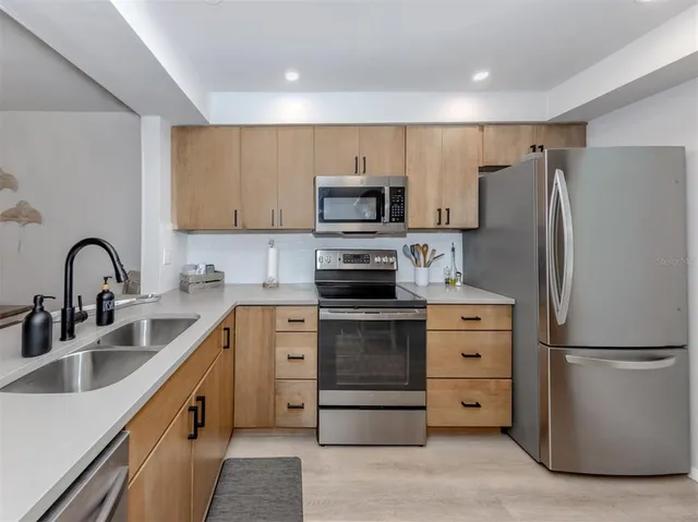 a kitchen with stainless steel appliances a refrigerator sink and cabinets
