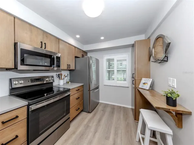a kitchen with stainless steel appliances a stove microwave and sink