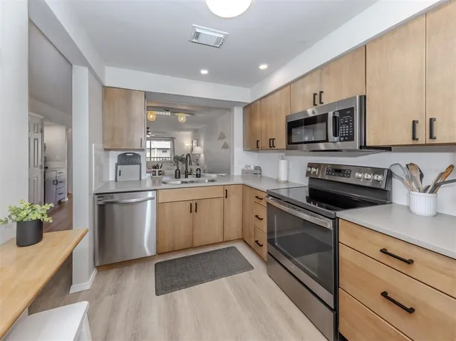 a kitchen with sink a microwave and cabinets