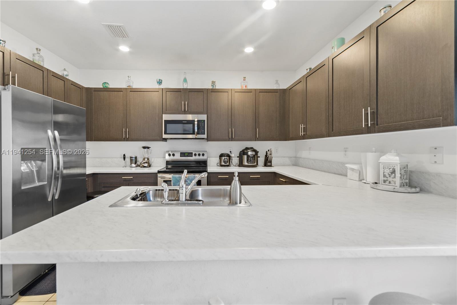 11805 Southwest 245 Terrace Homestead, FL 33032 - Photo 11 of 37 a kitchen with kitchen island a sink stainless steel appliances and cabinets