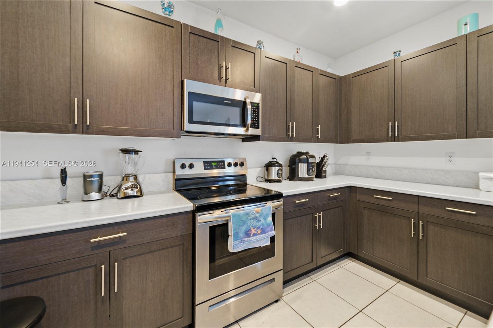 11805 Southwest 245 Terrace Homestead, FL 33032 - Photo 12 of 37 a kitchen with stainless steel appliances granite countertop a sink stove and microwave