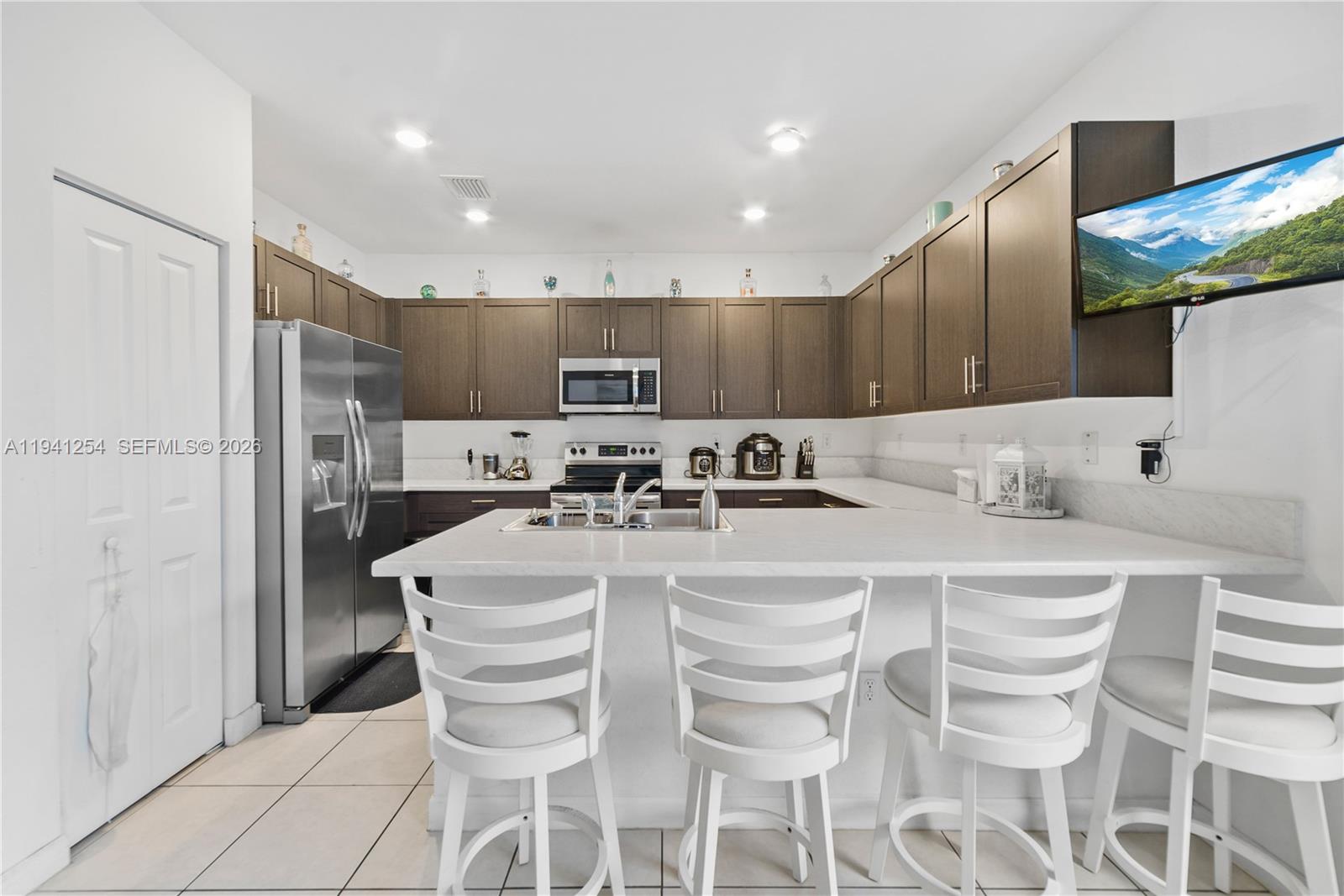 11805 Southwest 245 Terrace Homestead, FL 33032 - Photo 10 of 37 a kitchen with stainless steel appliances kitchen island granite countertop a refrigerator and a stove top oven