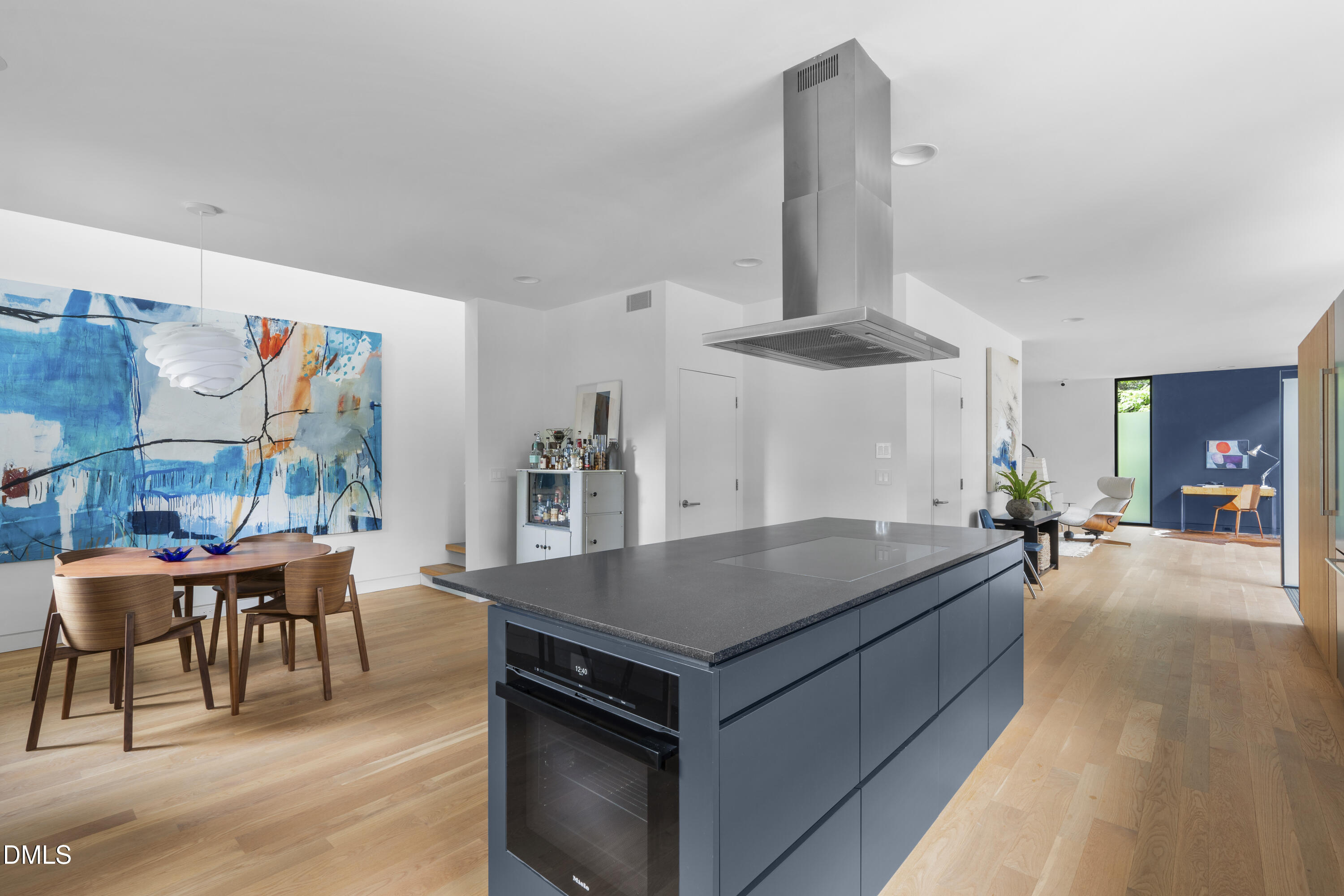 924 Tower Street Raleigh, NC 27607 - Photo 8 of 32 a living room with dining table and a wooden floor