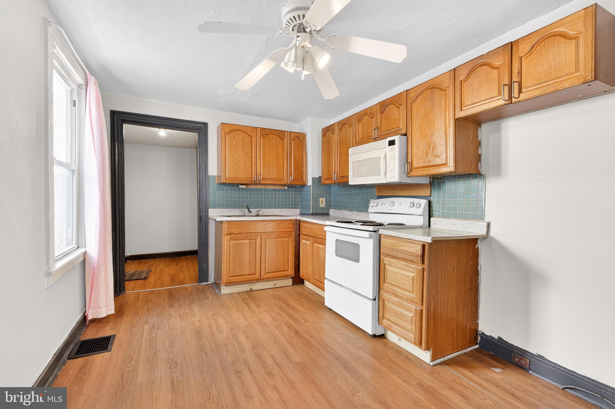 635 1st Street Lancaster, PA 17603 - Photo 9 of 32 a kitchen with granite countertop a stove a sink and white cabinets with wooden floor