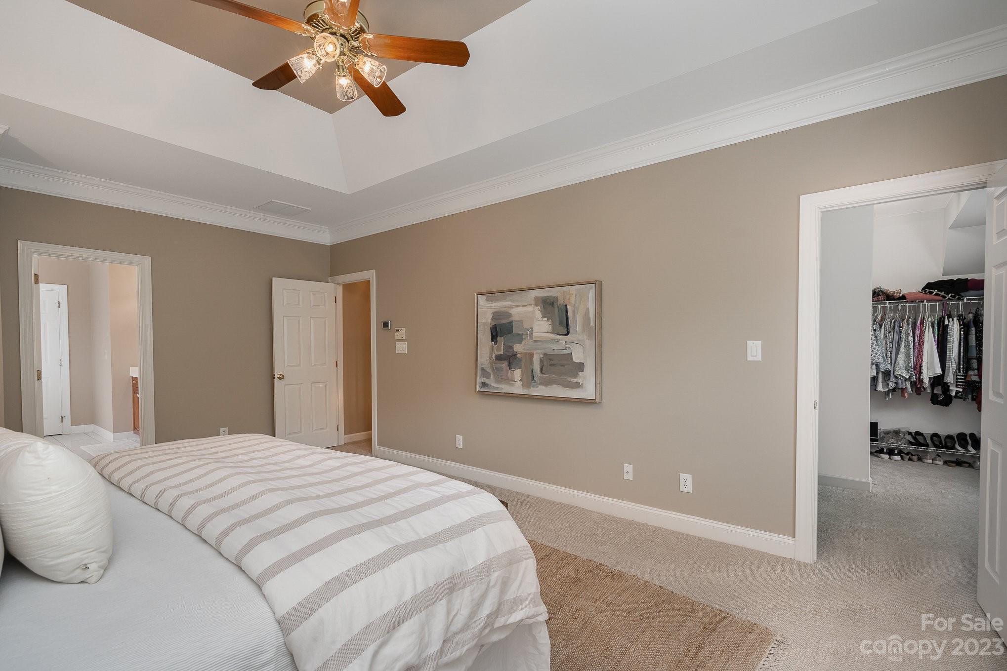 230 Sardis Pointe Road Matthews, NC 28105 - Photo 22 of 42 a bedroom with a large bed and a chandelier