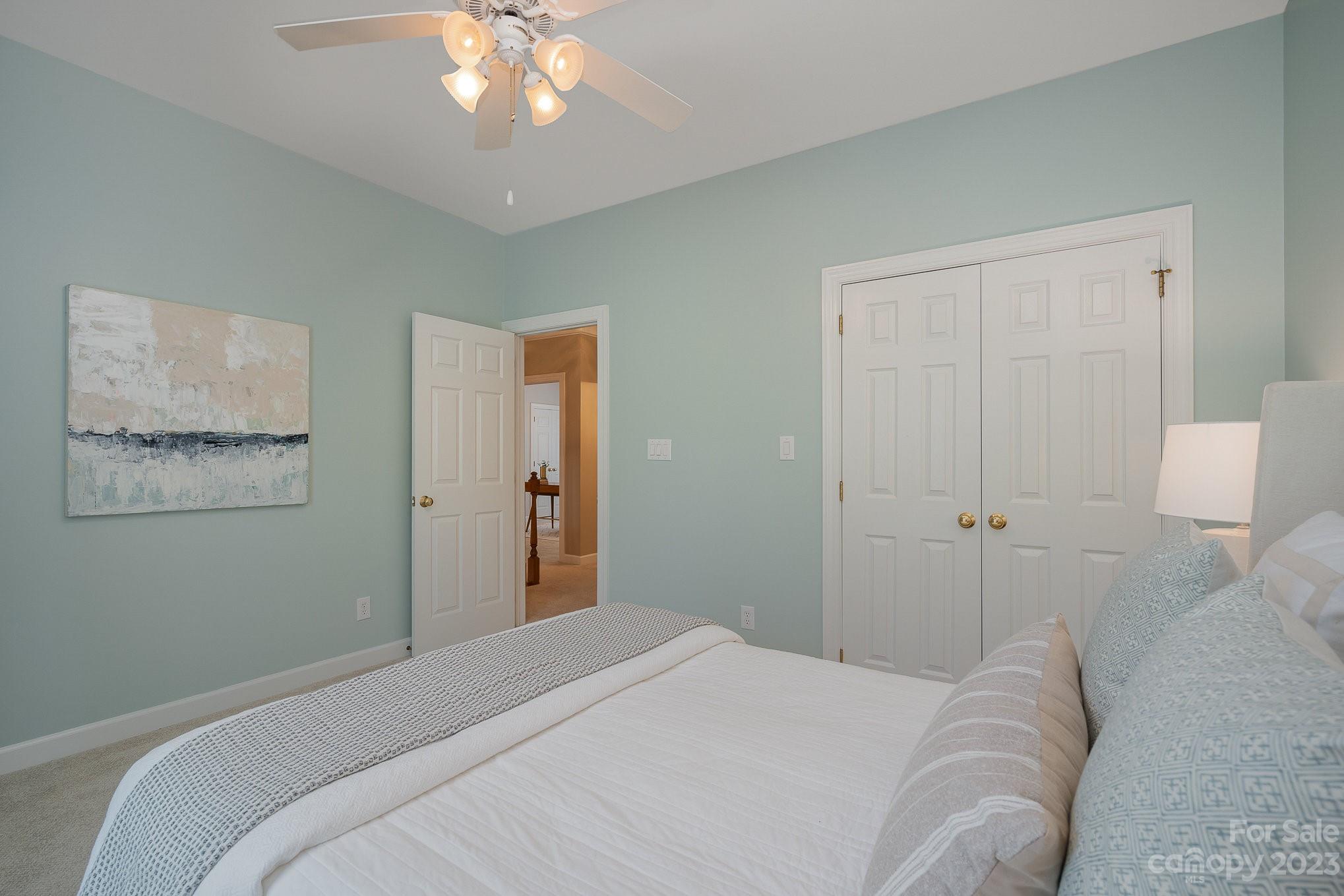 230 Sardis Pointe Road Matthews, NC 28105 - Photo 30 of 42 a bedroom with a bed and a chandelier