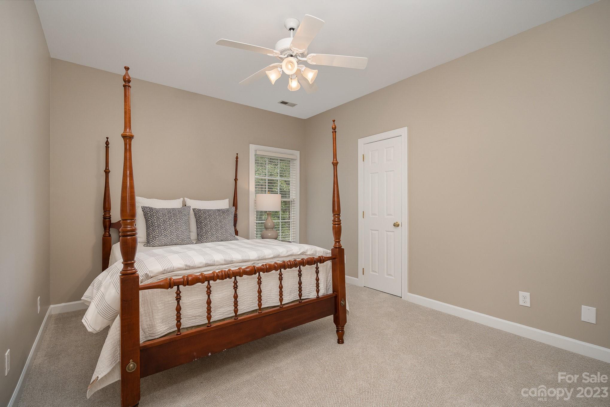 230 Sardis Pointe Road Matthews, NC 28105 - Photo 31 of 42 a bedroom with a bed and a chandelier