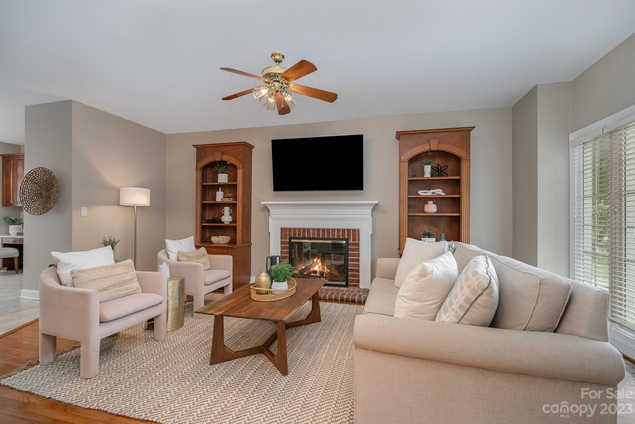 230 Sardis Pointe Road Matthews, NC 28105 - Photo 4 of 42 a living room with furniture a fireplace and a flat screen tv