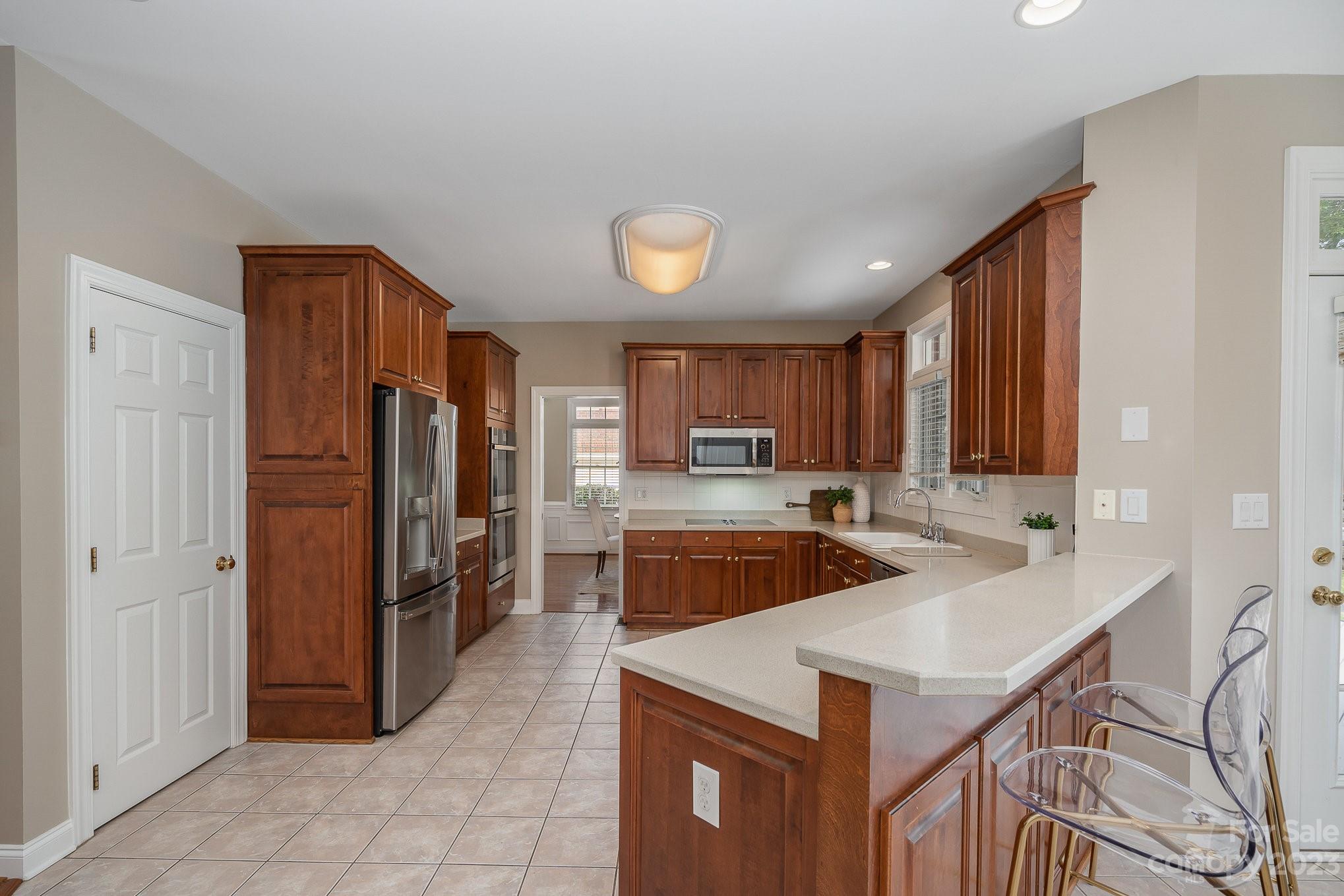 230 Sardis Pointe Road Matthews, NC 28105 - Photo 9 of 42 a kitchen with refrigerator and cabinets