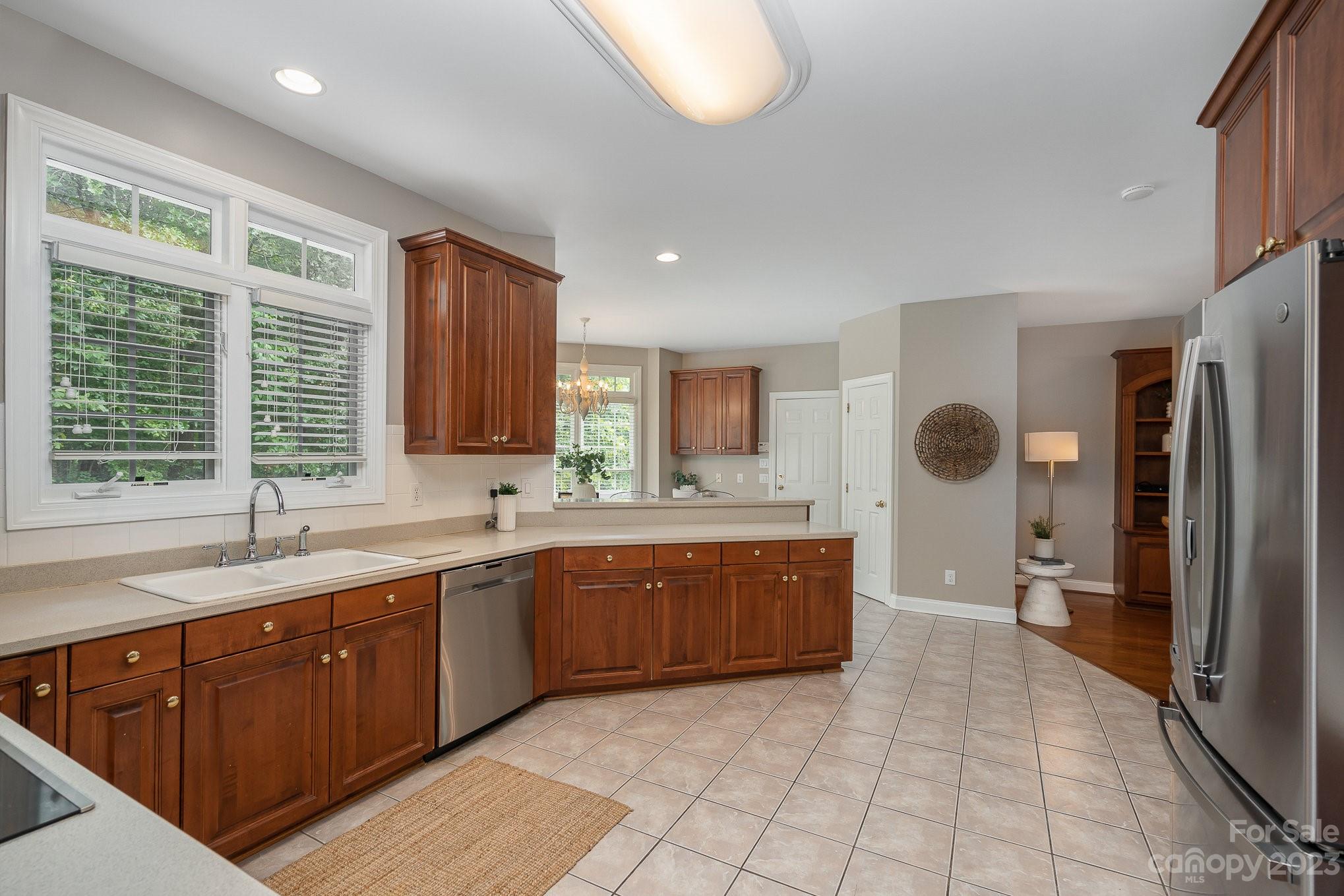 230 Sardis Pointe Road Matthews, NC 28105 - Photo 10 of 42 a large kitchen with stainless steel appliances granite countertop a sink and dishwasher with wooden cabinets