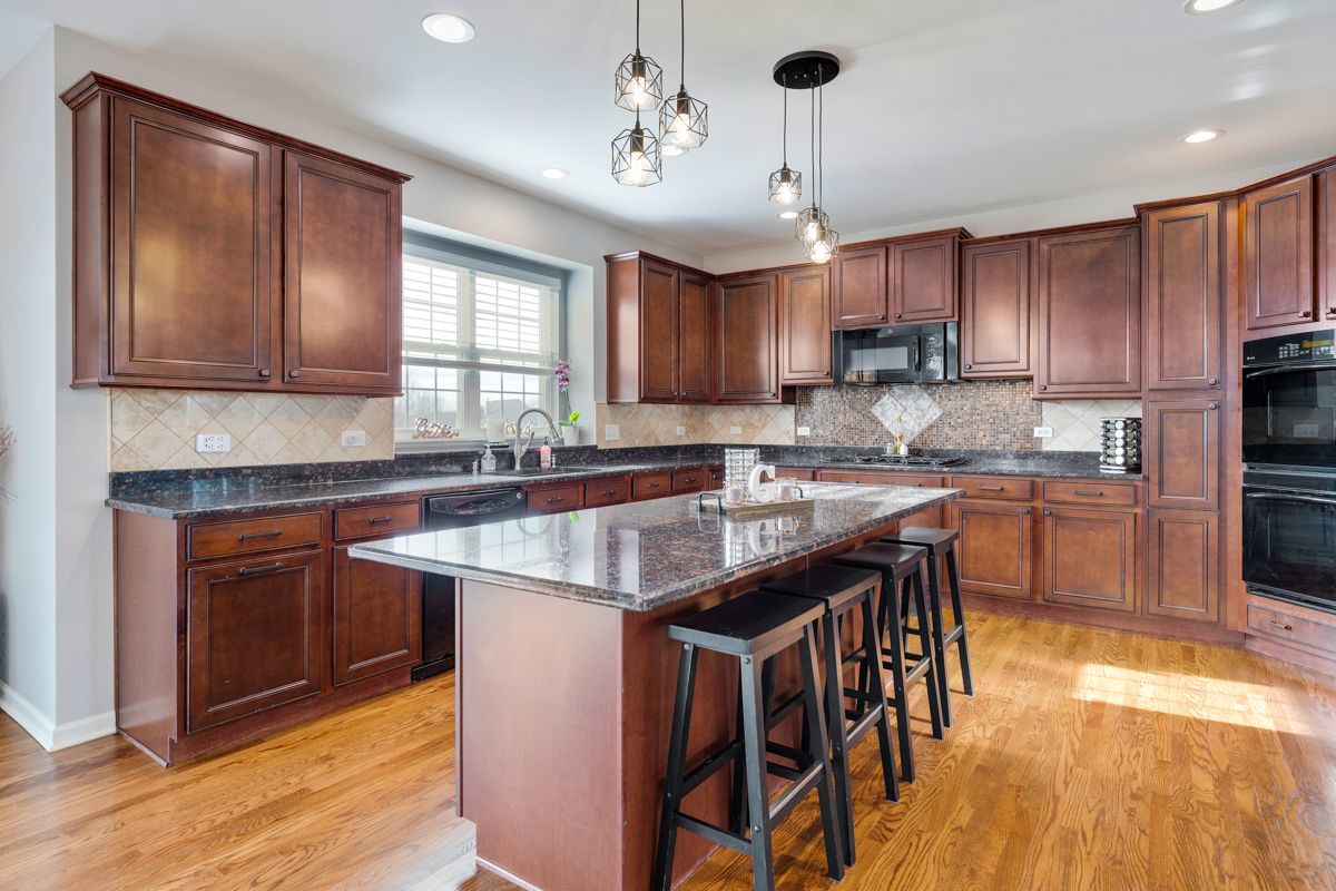 3001 Wagon Road Elgin, IL 60124 - Photo 12 of 39 a kitchen with stainless steel appliances granite countertop a sink a stove a refrigerator cabinets and a dining table