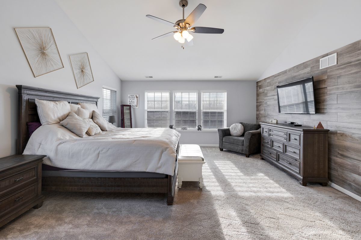 3001 Wagon Road Elgin, IL 60124 - Photo 15 of 39 a spacious bedroom with a bed a couch and a flat tv screen