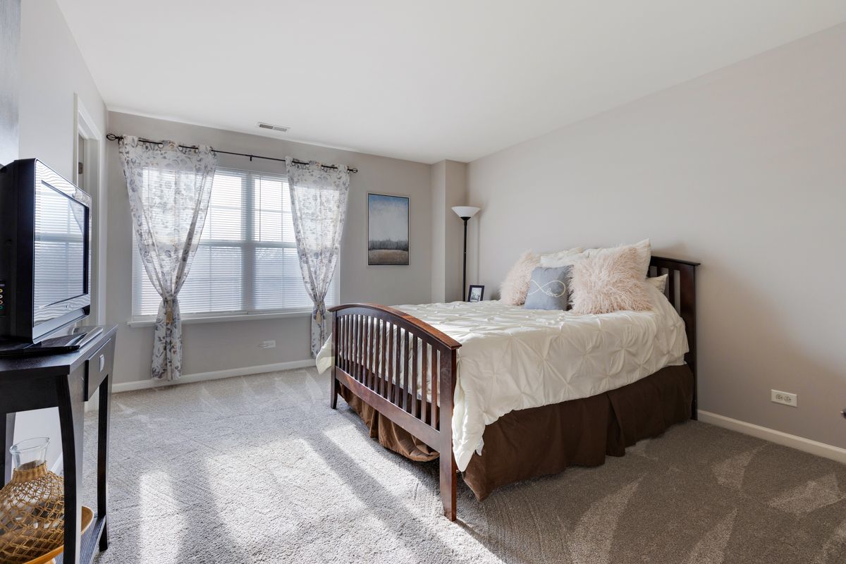 3001 Wagon Road Elgin, IL 60124 - Photo 19 of 39 a bedroom with a bed and a flat tv screen on the dresser