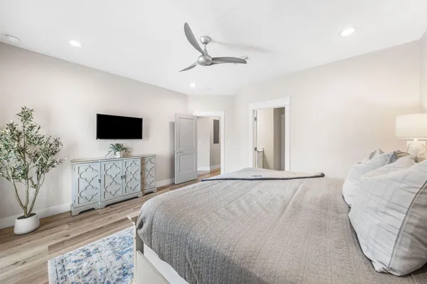 a bedroom with a large bed and a chandelier