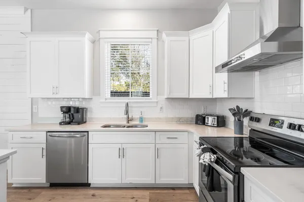 a kitchen with stainless steel appliances a stove a sink and a microwave