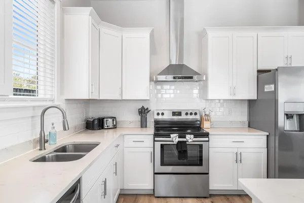 a large white kitchen with a stove oven and sink