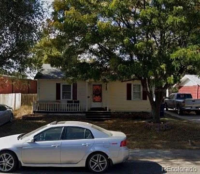 a front view of a house with cars parked