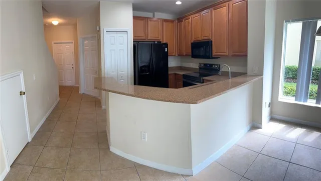 a kitchen with granite countertop a refrigerator and a stove top oven