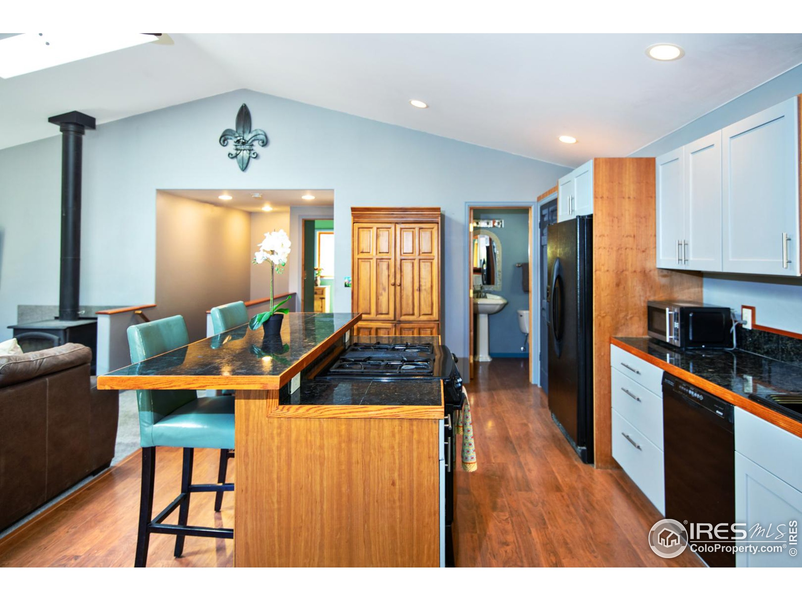 3727 Gamble Gulch Road Black Hawk, CO 80422 - Photo 13 of 30 a kitchen with stainless steel appliances granite countertop a refrigerator a stove a sink a dining table and chairs with wooden floor